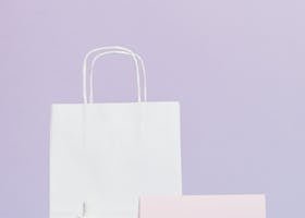 Elegant beauty product display with sale sign and shopping bag in minimalist style.