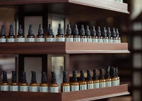 A rustic wooden shelf displaying brown bottles with labels in an apothecary setting.
