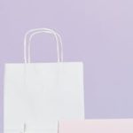 Elegant beauty product display with sale sign and shopping bag in minimalist style.